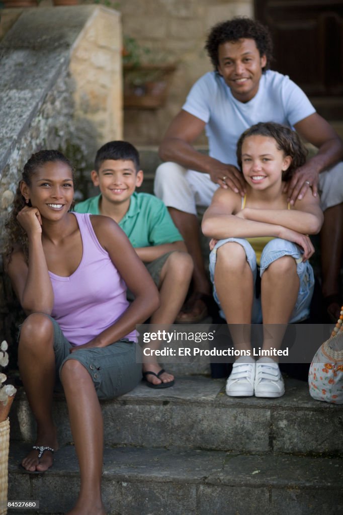 Mixed race family relaxing on stairs