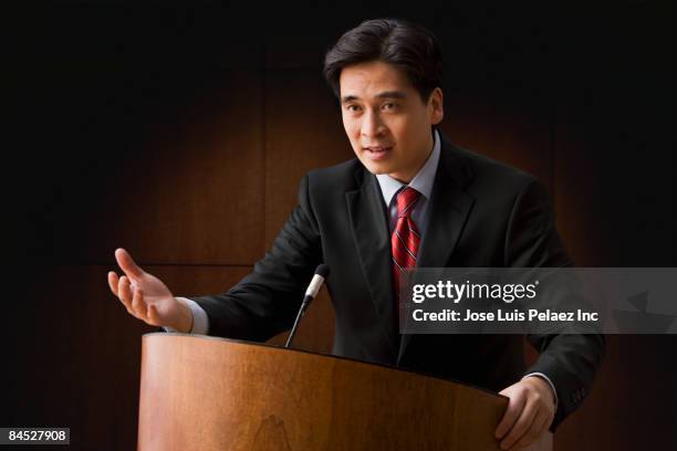 chinese businessman speaking at podium - microphone debate stock pictures, royalty-free photos & images