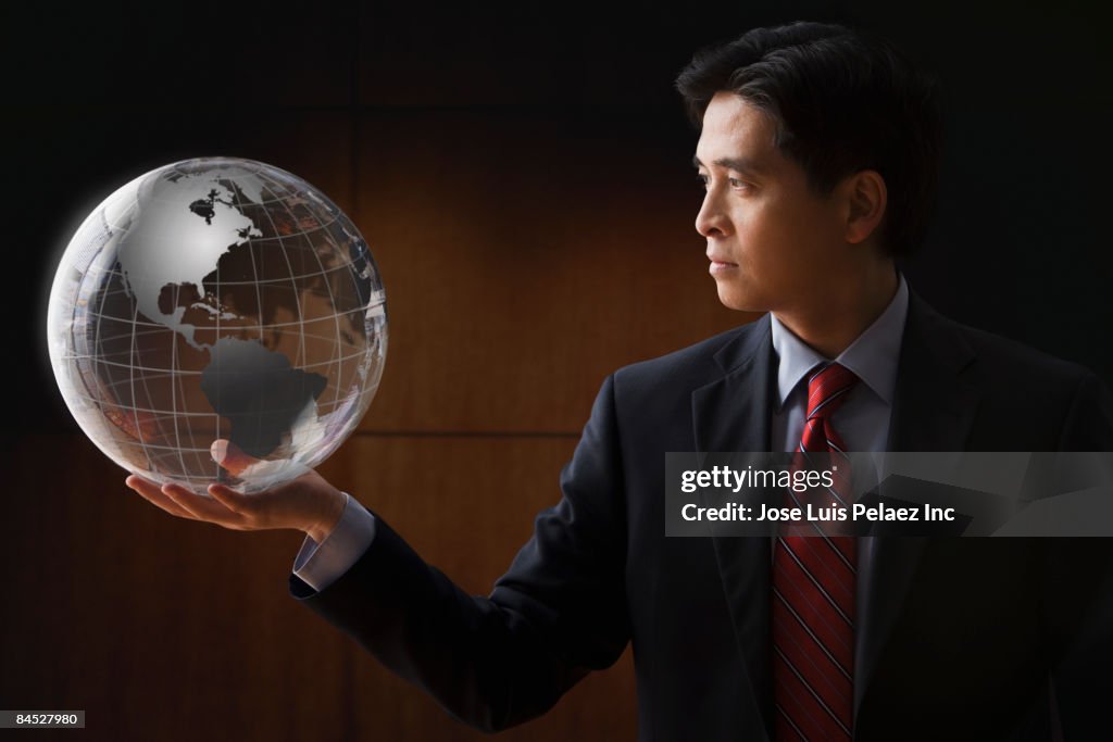 Chinese businessman holding glass globe