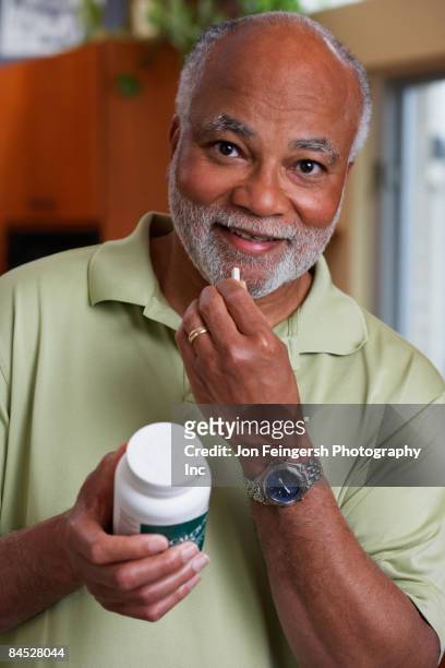 african man taking vitamin - tomando remédio - fotografias e filmes do acervo