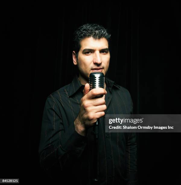 mixed race man standing at microphone - mixed race man standing studio stockfoto's en -beelden