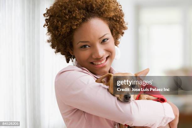 hispanic woman holding pet dog - frau chihuahua stock-fotos und bilder