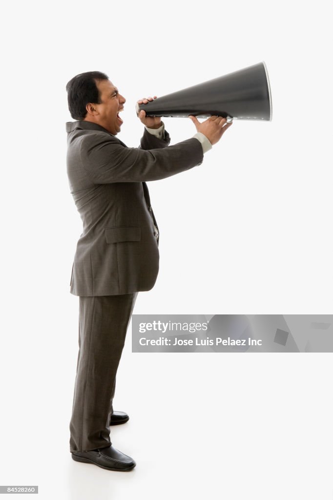 Hispanic businessman shouting into bull horn