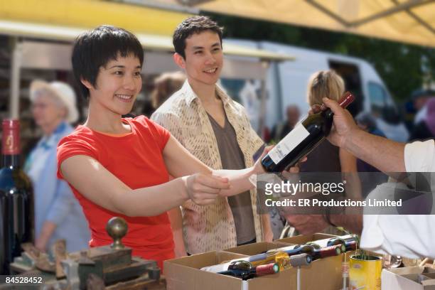 asian couple buying wine at outdoor market - vinger bildbanksfoton och bilder