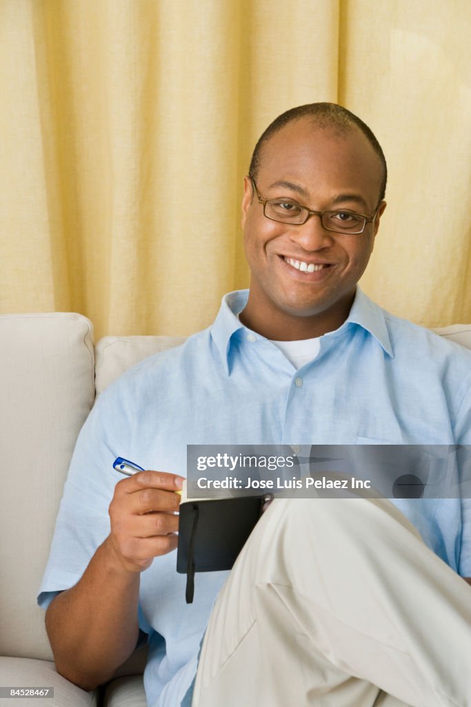 African man writing in notebook