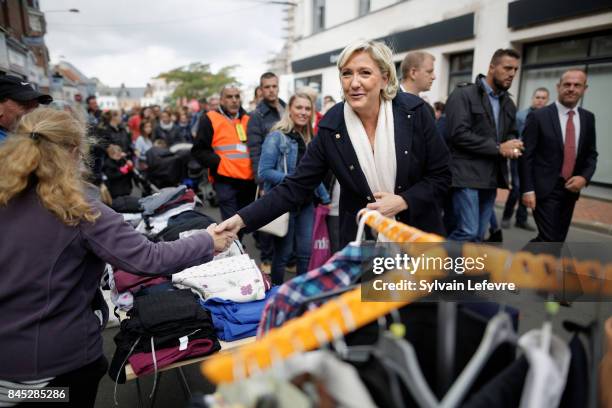 French far-right political party National Front leader Marine Le Pen greets supporters as she visits the "Henin-Beaumont Braderie" on September 10,...