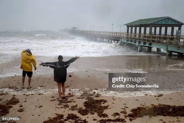 Mark Depenbrock and his daughter Chloe Depenbrock brace against tropical storm strength winds on the beach near Anglins Fishing Pier as Hurricane...