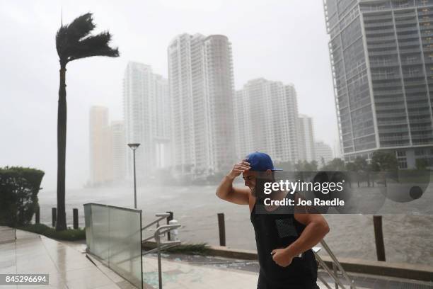 Person battles high winds and rain after taking pictures of the flooding along the Miami River as Hurricane Irma passes through on September 10, 2017...