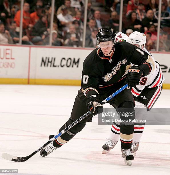 Cam Barker of the Chicago Blackhawks defends as Corey Perry of the Anaheim Ducks handles the puck during the game on January 28, 2009 at Honda Center...