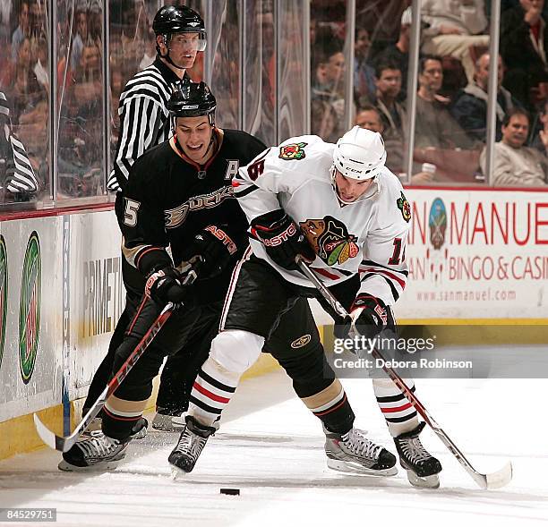 Andrew Ladd of the Chicago Blackhawks drives the puck alongside the boards against Ryan Getzlaf of the Anaheim Ducks during the game on January 28,...