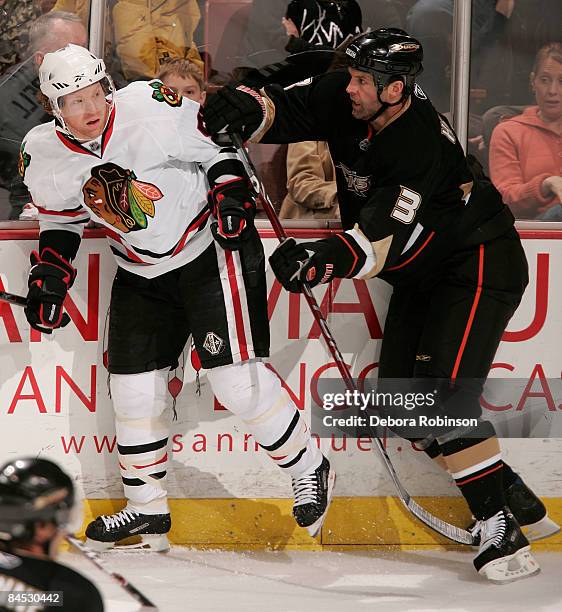 Brian Campbell of the Chicago Blackhawks gets bumped by Bret Hedican of the Anaheim Ducks during the game on January 28, 2009 at Honda Center in...