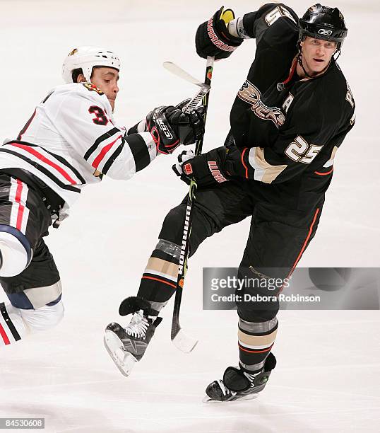 Dustin Byfuglien of the Chicago Blackhawks collides with Chris Pronger of the Anaheim Ducks during the game on January 28, 2009 at Honda Center in...