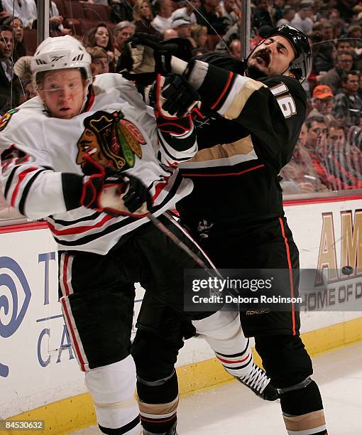 Brian Campbell of the Chicago Blackhawks gets hit from George Parros of the Anaheim Ducks during the game on January 28, 2009 at Honda Center in...