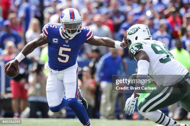 Tyrod Taylor of the Buffalo Bills runs the ball as Kony Ealy of the New York Jets attempts to tackle him during the first quarter on September 10,...