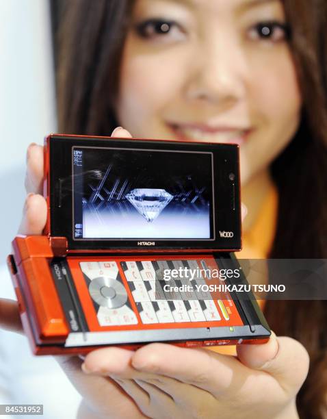 Model displays Japanese mobile communication giant KDDI's "Wooo mobile phone", produced by Hitachi at a Tokyo hotel on January 29, 2009. The new...