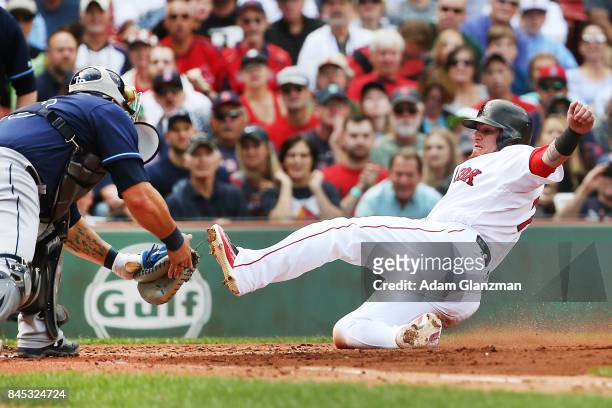 Christian Vazquez of the Boston Red Sox is tagged out at home plate by Wilson Ramos of the Tampa Bay Rays in the second inning of a game at Fenway...