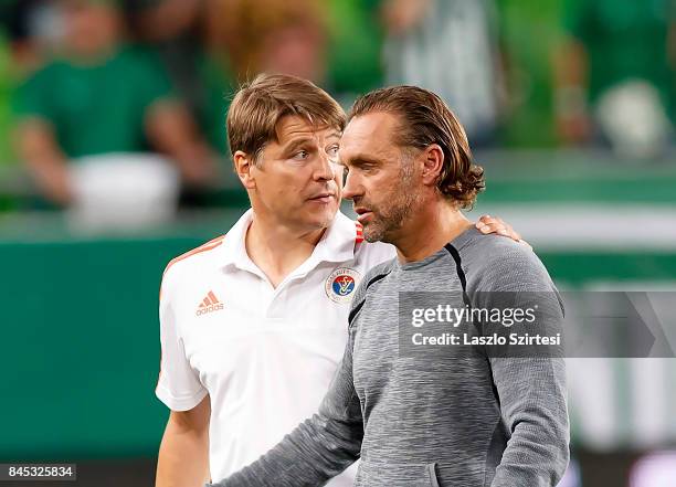 Head coach Michael Oenning of Vasas FC put his arm round head coach Thomas Doll of Ferencvarosi TC after the Hungarian OTP Bank Liga match between...