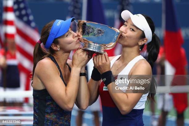 Martina Hingis of Switzerland and Yung-Jan Chan of Taiwan kiss the championship trophy after defeating Lucie Hradecka of Czech Republic and Katerina...