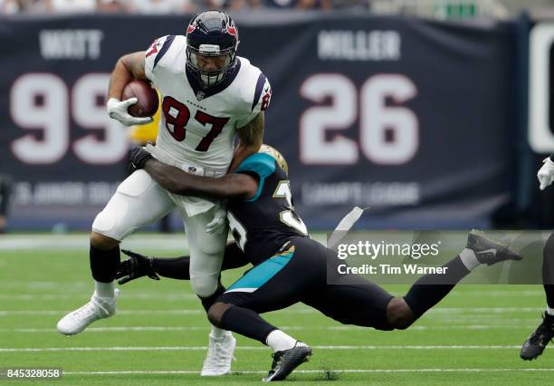 Fiedorowicz of the Houston Texans catches a pass and is tackled by Tashaun Gipson of the Jacksonville Jaguars in the second quarter at NRG Stadium on...