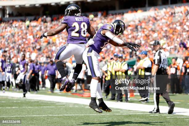 Terrance West of the Baltimore Ravens is congratulated by Javorius Allen of the Baltimore Ravens after scoring a touchdown during the second quarter...