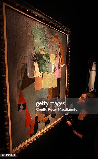 Christie's employee stands in front of Picasso's 'Instruments de musique sur un gueridon, 1914-15' and Mondrian's 'Composition avec bleu, rouge,...