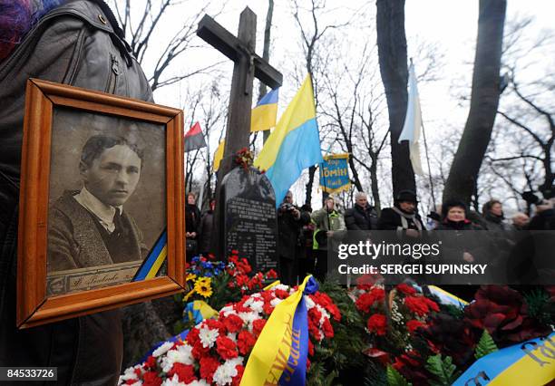 Relative holds picture of a died student decorated with memorial ribbon in Kiev on January 29 during rally and service on a grave of students and...