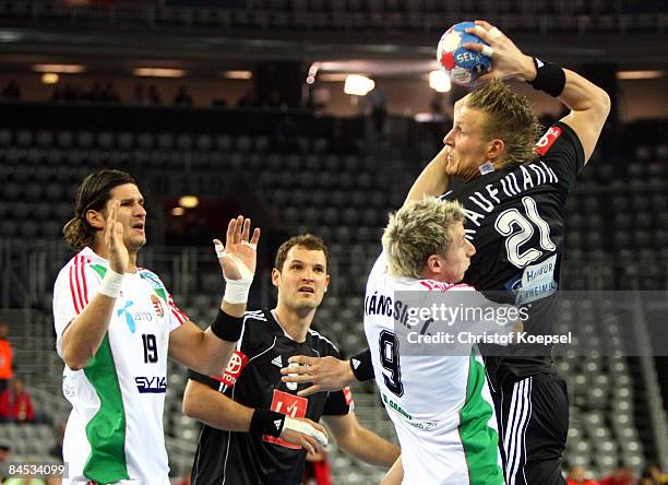 Lars Kaufmann of Germany throws the ball and Tamás Ivancsik of Hungary tackles him during the Men's World Handball Championships placement match of...