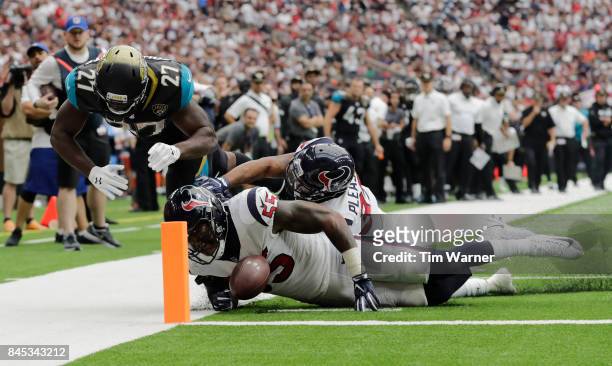 Leonard Fournette of the Jacksonville Jaguars fumbles the ball defended by Benardrick McKinney and Eddie Pleasant of the Houston Texans during the...