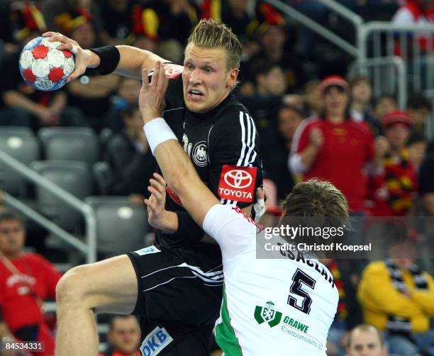 Gábor Császár of Hungary tackles Lars Kaufmann of Germany during the Men's World Handball Championships placement match of place five between Hungary...