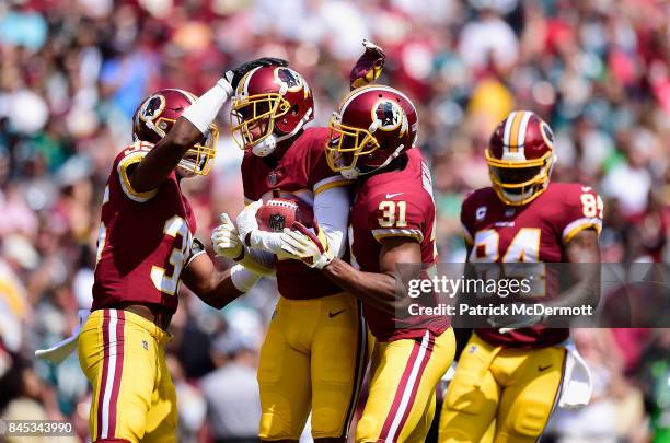 Ryan Kerrigan of the Washington Redskins celebrates with teamates against the Philadelphia Eagles in the second quarter at FedExField on September...