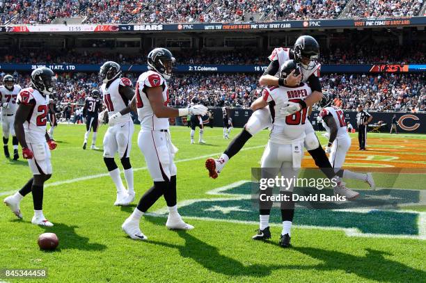 Quarterback Matt Ryan of the Atlanta Falcons celebrates with Austin Hooper after Hooper scored a touchdown in the fourth quarter against the Chicago...