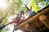 Little girl helping her brother on ropes course