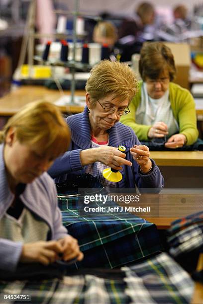 Staff at the 200 year old MacNaughton Holdings Ltd prepare new kilts at their factory on January 29, 2009 in Paisley, Scotland. Scottish kilt makers...