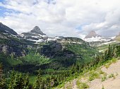 Going to the Sun Road, View of Landscape, snow fields In Glacier National Park around Logan Pass, Hidden Lake, Highline Trail, which features waterfalls, wildlife, and is surrounded by mountains including: Piegan, Pollock, Oberlin, Clements, Reynolds