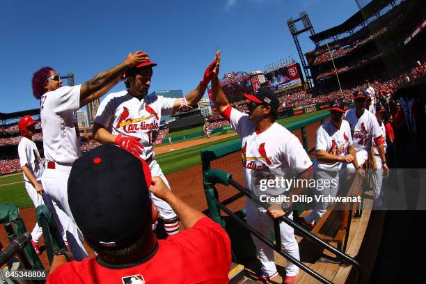 Randal Grichuk of the St. Louis Cardinals is congratulated by manager Mike Matheny and Carlos Martinez of the St. Louis Cardinals after hitting a...