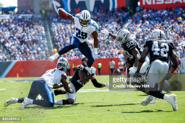 Running back Demarco Murray of the Tennessee Titans hurdles corner back David Amerson of the Oakland Raiders in the second half at Nissan Stadium on...