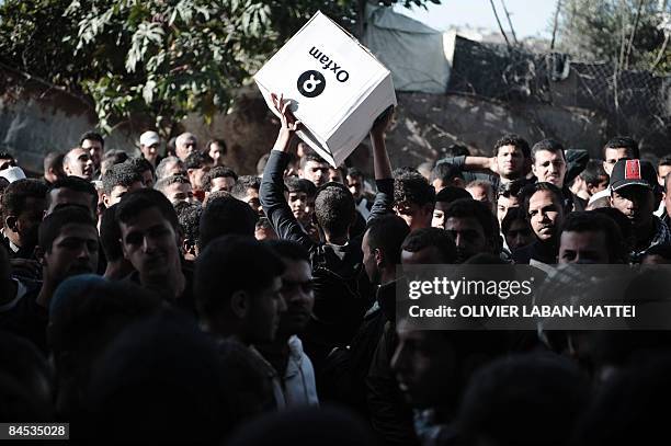 Palestinian man carries a box of hygiene supplies outside the Oxfam warehouse in Gaza City on January 29, 2009 during a hygiene supplies distribution...