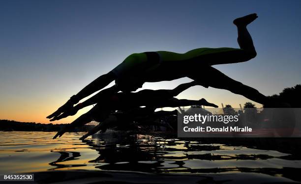 The men's professional triathletes start with the sunrise on the Tennessee River with John Ross Bridge in the background during the Men's IRONMAN...