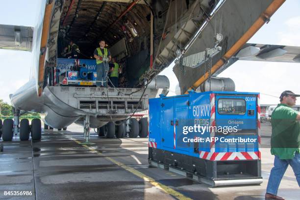 People unload a Ilyushin 76 airplane carrying EDF material for the French Caribbean islands of Saint Martin and Saint Barthelemy after the passage of...