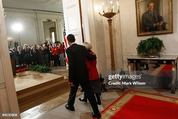 President Barack Obama walks with Lilly Ledbetter into the East Room before signing the "Lilly Ledbetter Fair Pay Act during an event at the White...