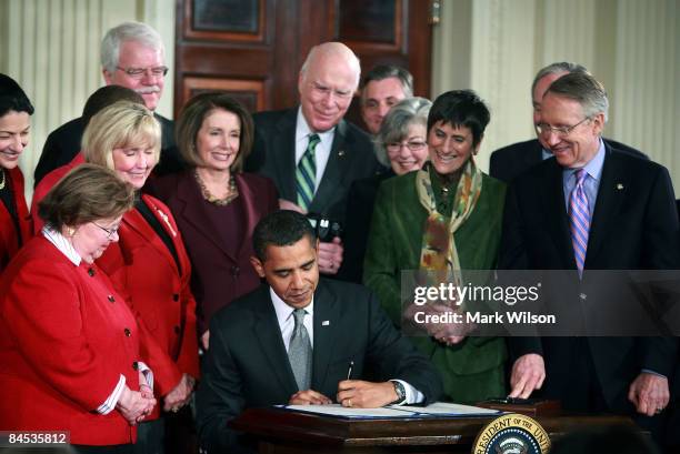 Surrounded by members of congress U.S. President Barack Obama signs the "Lilly Ledbetter Fair Pay Act duringn an event in the East Room of the White...
