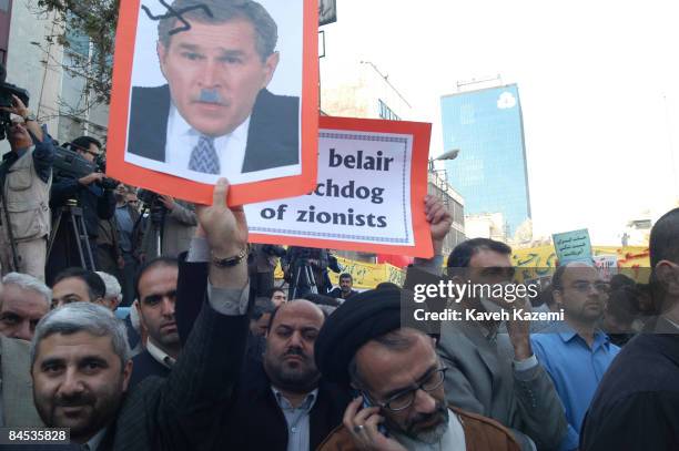 Iranian demonstrators with a poster comparing US President George W. Bush to Adolf Hitler, at a demonstration outside the former American embassy in...