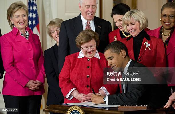 President Barack Obama, surrounded by lawmakers, US Secretary of State Hillary Clinton Sen. Barbara Mikulski D-MD, House Majority Leader Steny Hoyer...