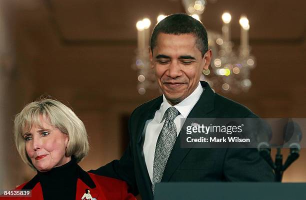 President Barack Obama stands with Lilly Ledbetter before signing the "Lilly Ledbetter Fair Pay Act duringn an event in the East Room of the White...