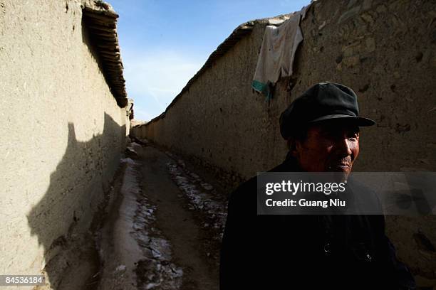 Resident walks next to Tang Dynasty buildings which stand in the ancient 'Kaiyang Fort' on January 29, 2009 in Yangyuan, China. People still reside...