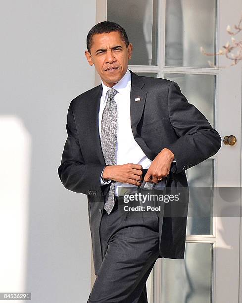 President Barack Obama puts away his Blackberry on his belt as he returns to the Oval Office at the White House January 29, 2009 in Washington, DC....