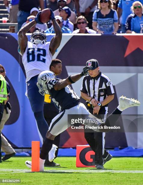 Delanie Walker of the Tennessee Titans jumps to attempt a reception against Karl Joseph of the Oakland Raiders during the second half at Nissan...