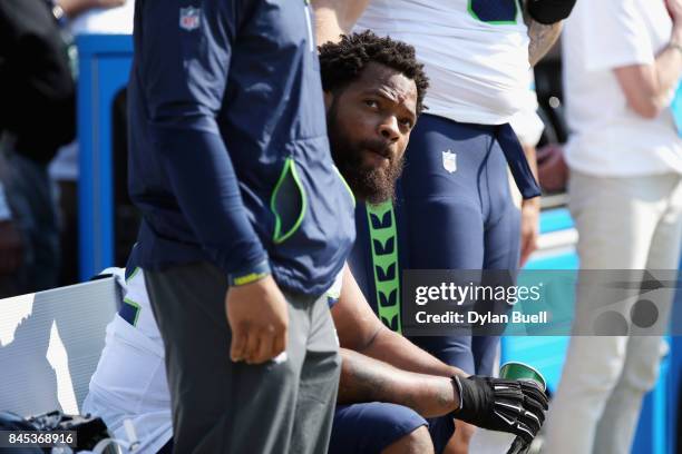 Michael Bennett of the Seattle Seahawks sits on the bench during the national anthem prior to the game against the Green Bay Packers at Lambeau Field...