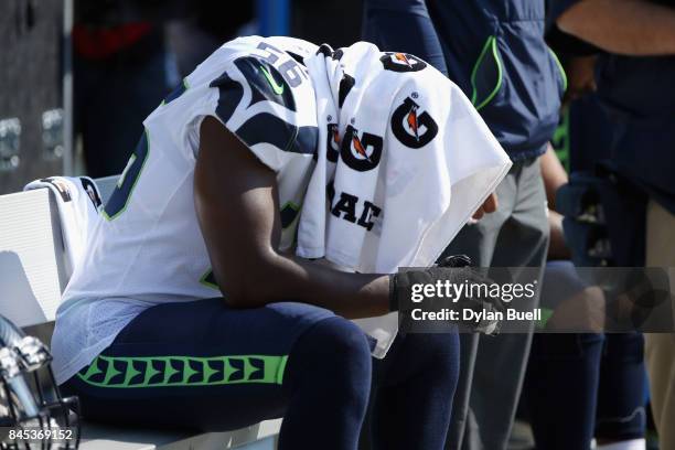 Cliff Avril of the Seattle Seahawks sits on the bench during the national anthem prior to the game against the Green Bay Packers at Lambeau Field on...
