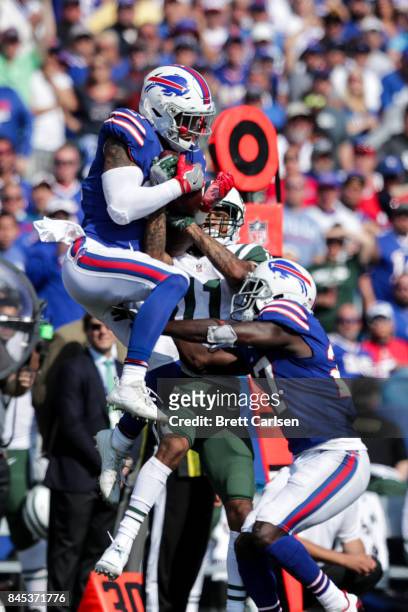 Jordan Poyer of the Buffalo Bills and Robby Anderson of the New York Jets and Tre'Davious White of the Buffalo Bills go for the ball during the...